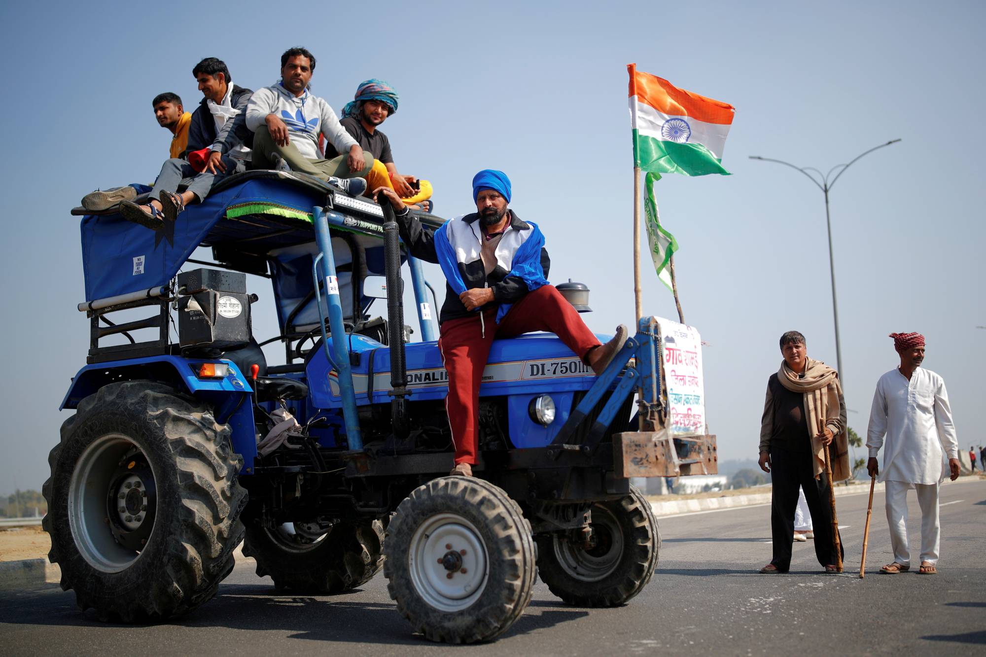 Indian farmers take part in a road-block protest against farm laws on the outskirts of New Delhi on Saturday. | REUTERS