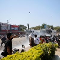 Police fire a water cannon during clashes with protestors rallying against the military coup and demanding the release of elected leader Aung San Suu Kyi in Naypyitaw, Myanmar, on Tuesday. | REUTERS