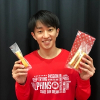 Nagoya guard Takumi Saito holds snacks in packaging created with biomass materials. | COURTESY OF THE NAGOYA DIAMOND DOLPHINS
