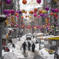 Pedestrians make their way through the Chinatown neighborhood of lower Manhattan, New York, on Feb. 2. | TODD HEISLER / THE NEW YORK TIMES