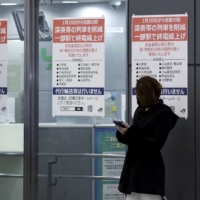 Notices are displayed announcing the suspension of late-night train services at JR Shinjuku Station in Tokyo on Jan. 20. | BLOOMBERG