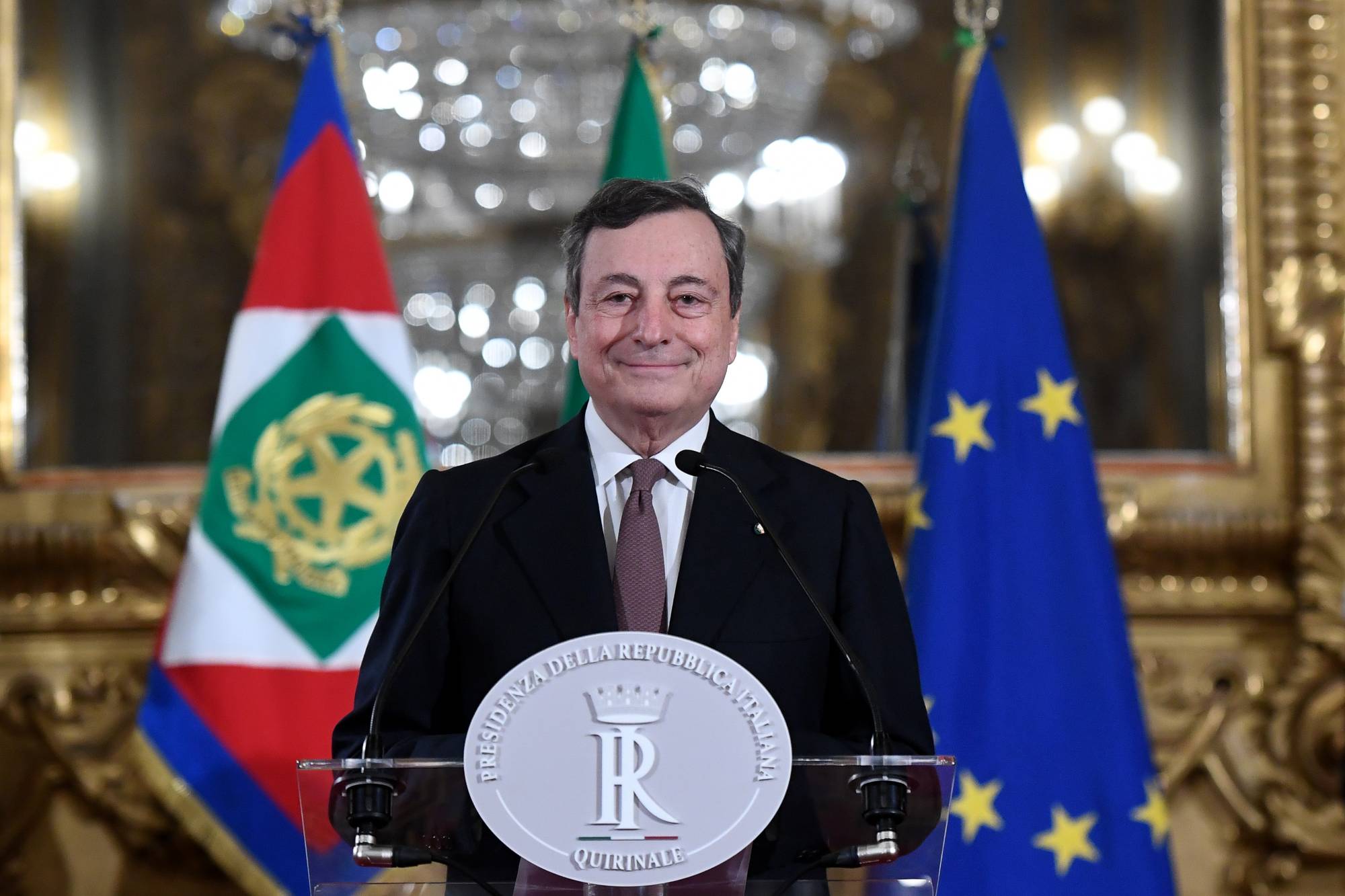 Mario Draghi, Italy's prime minister-designate, smiles at a news conference following a meeting with Italian President Sergio Mattarella in Rome on Friday. | ALESSANDRO DI MEO / ANSA / VIA BLOOMBERG