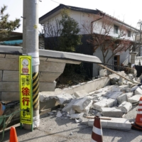 Bricks from a collapsed wall are seen on a street in Kunimi, Fukushima Prefecture, on Sunday, a day after an earthquake with a magnitude of 7.3 struck northeastern Japan. | KYODO