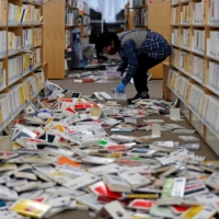 A staff member picks up books at Iwaki City library in Fukushima Prefecture. | REUTERS