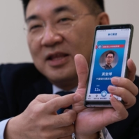 Johnny Chiang, chairman of the Kuomintang, displays his party\'s app at their headquarters in Taipei on Jan. 28. The Beijing-friendly party, which long held an iron grip on the island, is struggling to stay relevant at a time when many residents are wary of China\'s ambitions.  | ASHLEY PON/THE NEW YORK TIMES
