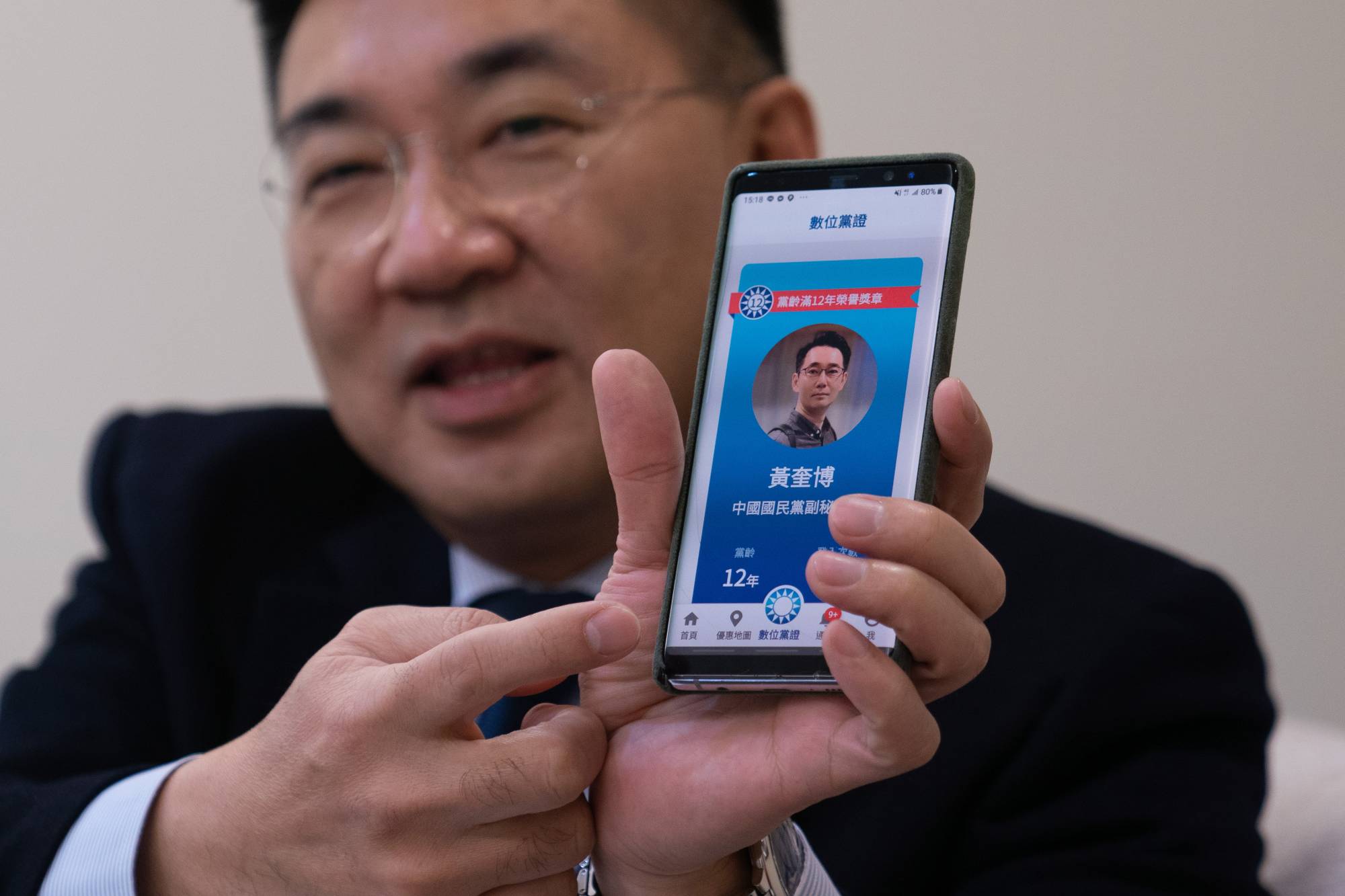 Johnny Chiang, chairman of the Kuomintang, displays his party's app at their headquarters in Taipei on Jan. 28. The Beijing-friendly party, which long held an iron grip on the island, is struggling to stay relevant at a time when many residents are wary of China's ambitions.  | ASHLEY PON/THE NEW YORK TIMES