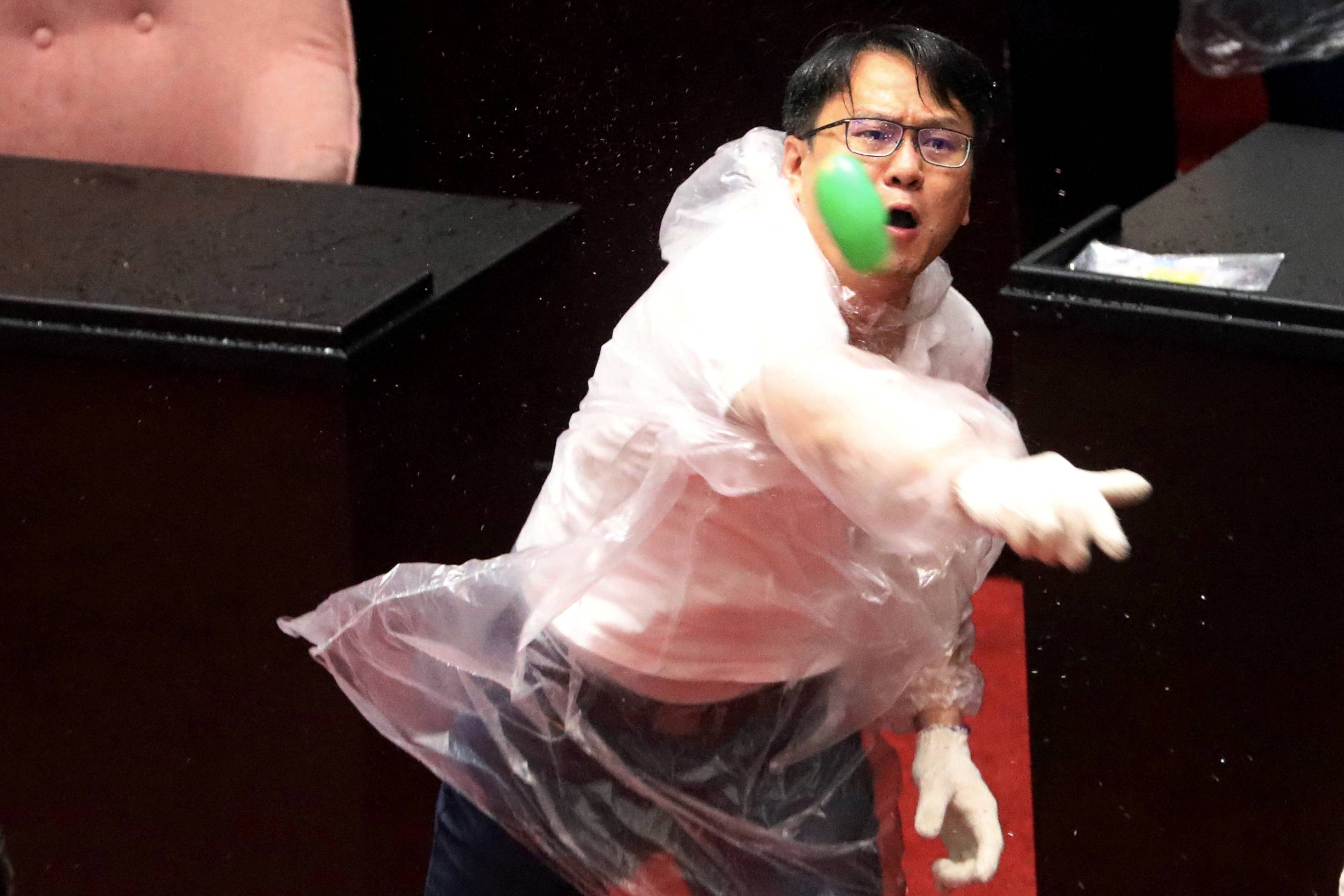 Lawmakers from Taiwan's Democratic Progressive Party and the Kuomintang throw water balloons at each other inside the parliament in Taipei last July. | REUTERS
