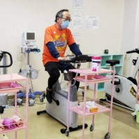 Manabu Yoneshima, manager of Municipal Tsuruga Hospital and Tokyo 2020 Olympic Games torch relay runner, works out on a bike in his hospital\'s rehabilitation room in Tsuruga, Fukui Prefecture. | REUTERS