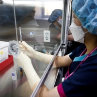 A nurse takes part in a coronavirus vaccination drill at a COVID-19 vaccination center in Seoul on Feb. 9. | POOL / VIA REUTERS