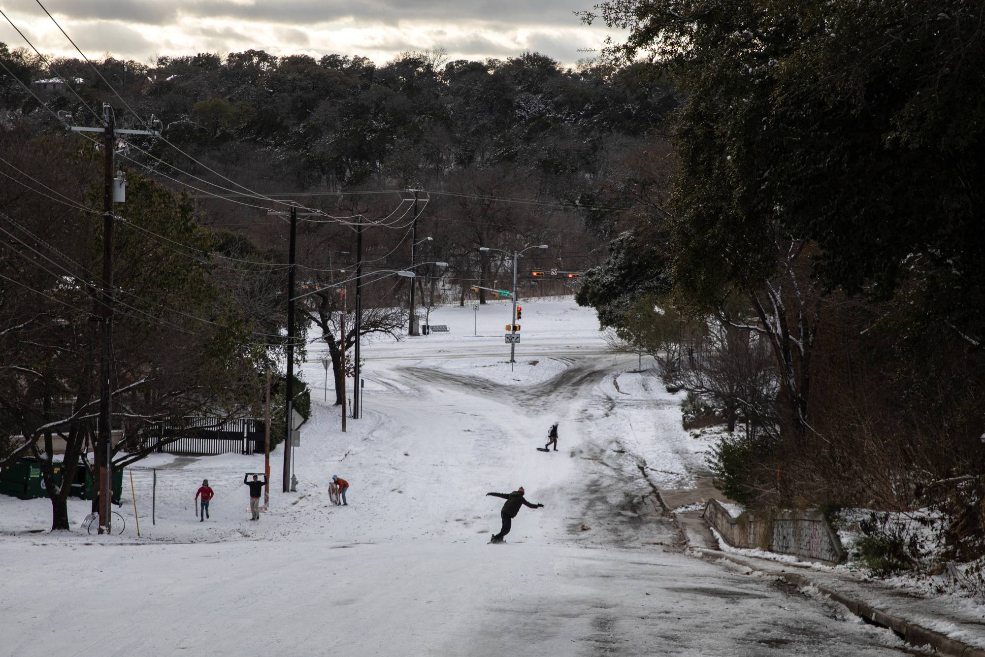 A man snowboards down a road in Austin, Texas, on Monday. | Tamir Kalifa / The New York Times