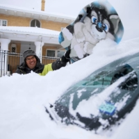 Francisco Sanchez wipes snow off his car with a boogie board in El Paso, Texas, on Sunday.  | EL PASO TIMES / USA TODAY NETWORK / VIA REUTERS