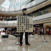 A pro-democracy demonstrator takes part in a lunchtime protest against the national security law at a shopping mall in Hong Kong in July 2020.  | REUTERS 