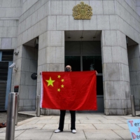 An activist holds the national flag of China outside the British Consulate-General in Hong Kong on Feb. 1. | AFP-JIJI