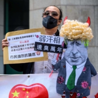 A caricature of British Prime Minister Boris Johnson is displayed by pro-Beijing activists as they gather outside the British Consulate-General to protest against the use of the British National (Overseas) passport in Hong Kong on Feb. 1. | AFP-JIJI
