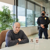 Aaron Davis visits his two LeBron James cards, seen on the table, with a security guard present at a bank in San Diego on Feb. 13. | JOHN FRANCIS PETERS / THE NEW YORK TIMES