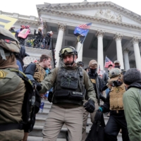 Jessica Watkins (left) and Donovan Crowl (center), both from Ohio, march down the east front steps of the U.S. Capitol with the Oath Keepers militia group among supporters of U.S. President Donald Trump protesting against the certification of the 2020 U.S. presidential election results by the Congress, in Washington on Jan. 6. | REUTERS