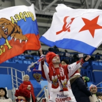 A fan waves flags while cheering on the Olympic Athletes from Russia during a hockey game at the 2018 Pyeongchang Winter Olympics on Feb 23, 2018. | REUTERS