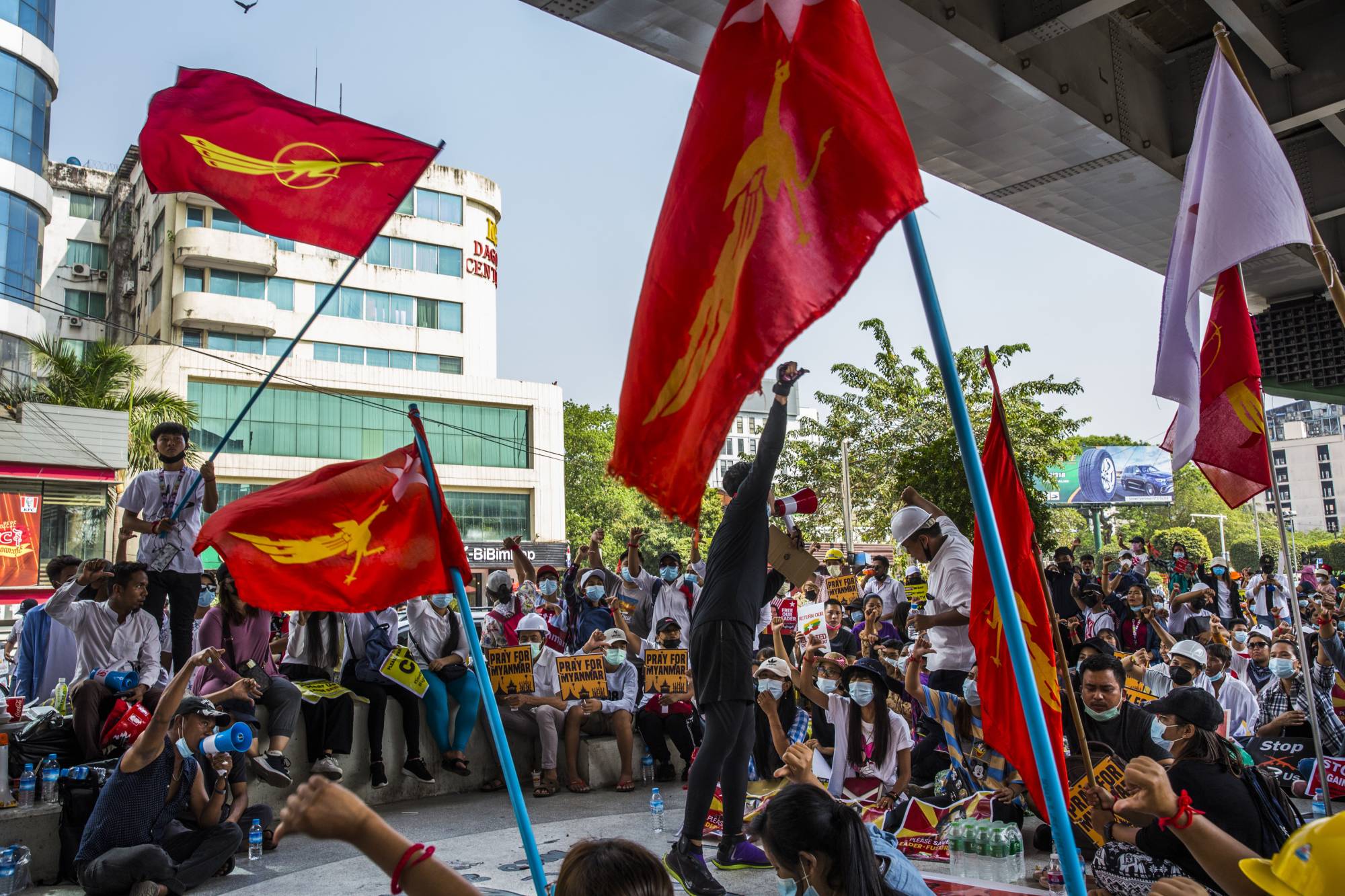 A protester speaks to a group gathered to demonstrate against the military coup, in Yangon, Myanmar, on Tuesday. | The New York Times