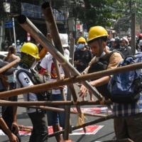 Protesters erect makeshift barricades to obstruct security forces during a demonstration against the military coup in Yangon on Sunday.  | AFP-JIJI