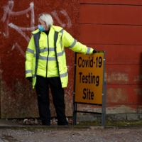 A member of NHS Test and Trace staff sets up a mobile COVID-19 testing center in the Moston area of Manchester, Britain, on Feb. 17. | REUTERS 