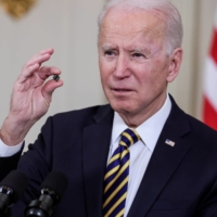 U.S. President Joe Biden holds a semiconductor chip as he speaks at the White House on Feb. 24 prior to signing an executive order aimed at addressing a global semiconductor chip shortage. | REUTERS 
