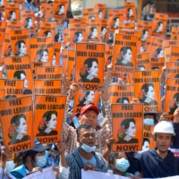 Protesters hold posters with the image of detained civilian leader Aung San Suu Kyi during a demonstration against the military coup in Naypyidaw on Sunday.  | AFP-JIJI