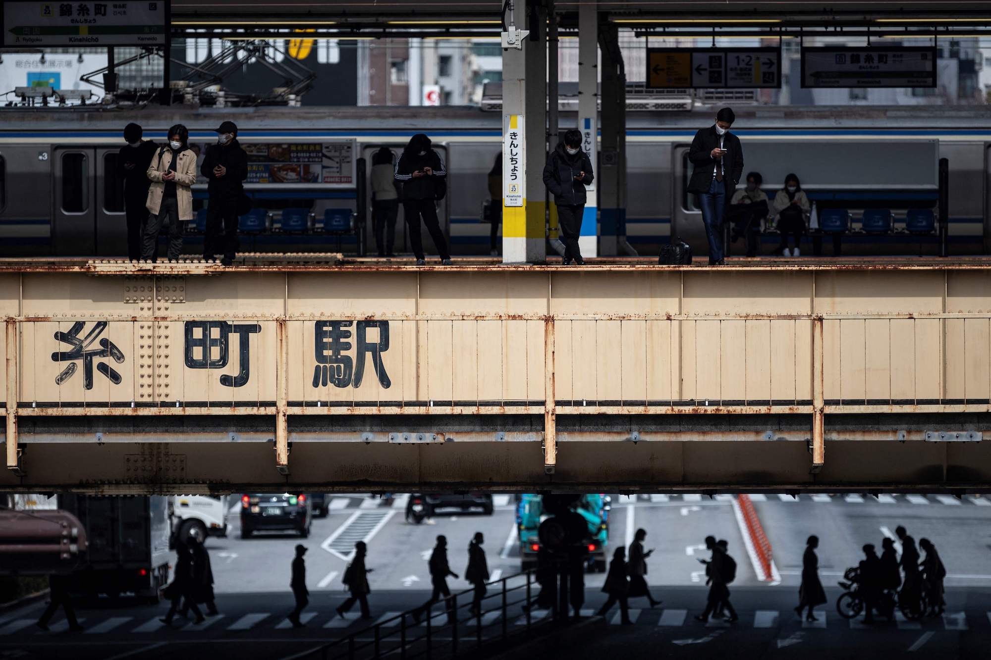 People wait for train on a platform in Tokyo on March 5. | AFP-JIJI