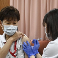 A medical worker gets a second dose of COVID-19 vaccine at a Tokyo hospital on March 10.  | KYODO