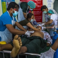 A man receives medical attention after being shot in the head by security forces in Mandalay, Myanmar, on Sunday. After four weeks of protests, the military in Myanmar opened fire on demonstrators in several cities on Sunday, killing at least 18 people, the United Nations said, in the most vicious effort yet to extinguish the unrest roiling the nation.  | THE NEW YORK TIMES