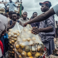 Traders unload sacks of oranges from a delivery truck at a market in Mararaba, Nigeria, in September. | BLOOMBERG