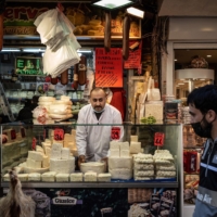 A cheesemonger looks out from his stall in Istanbul on Feb. 2. | BLOOMBERG