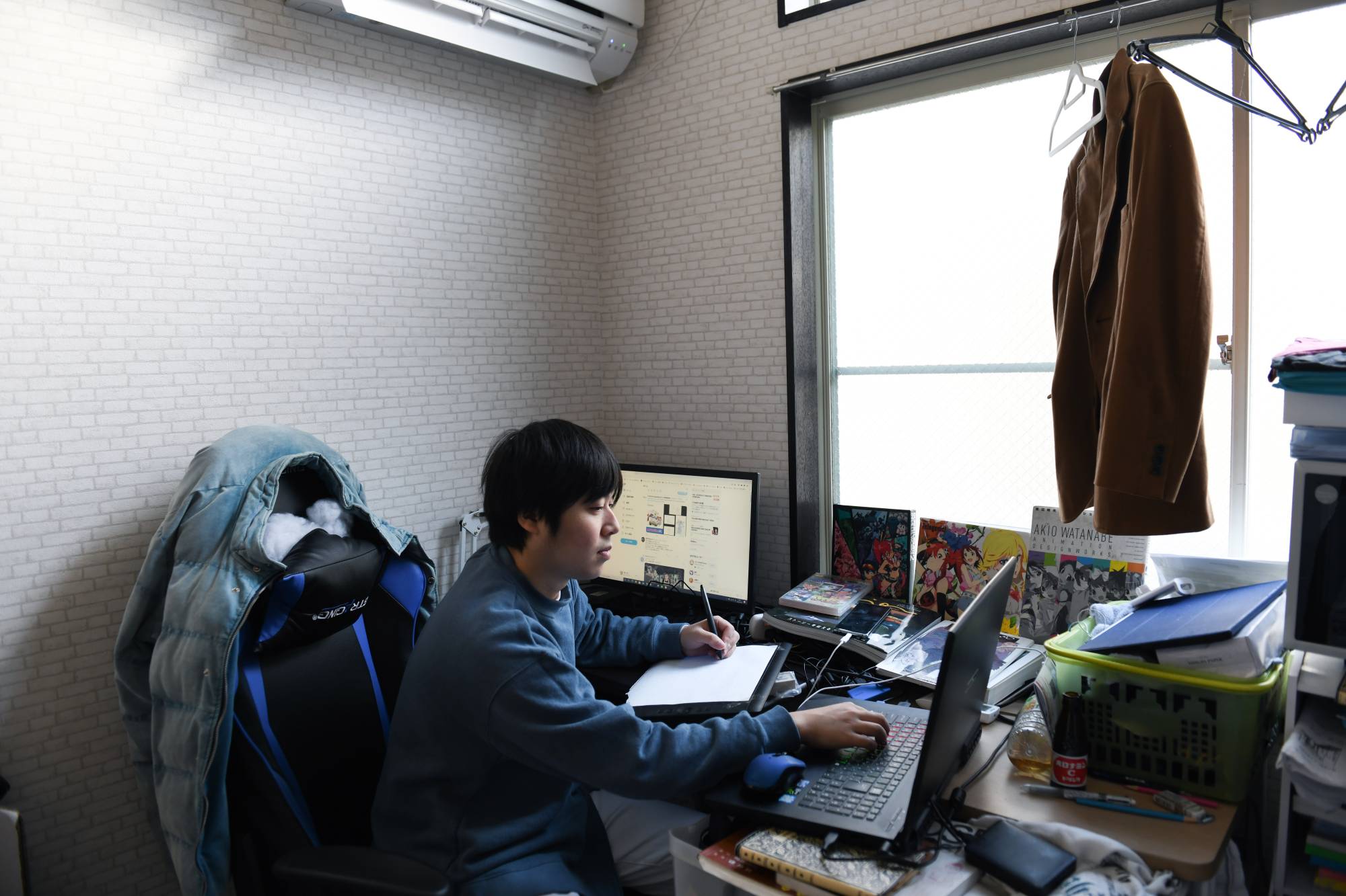 Tetsuya Akutsu, a freelance animator, at work in his apartment in Tokyo on Jan. 14. Akutsu wants to start a family, but on his wages, he says, 'it’s impossible to get married and to raise a child.' | NORIKO HAYASHI/THE NEW YORK TIMES