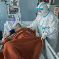 A medical worker treats a patient suffering from COVID-19 at the Clinical Hospital Center in Nis, Serbia, on Wednesday.  | REUTERS 