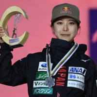 Sara Takanashi holds her trophy on the podium after finishing second in the women\'s large hill jumping event at the FIS Nordic Ski World Championships in Oberstdorf, Germany, on Wednesday. | AFP-JIJI