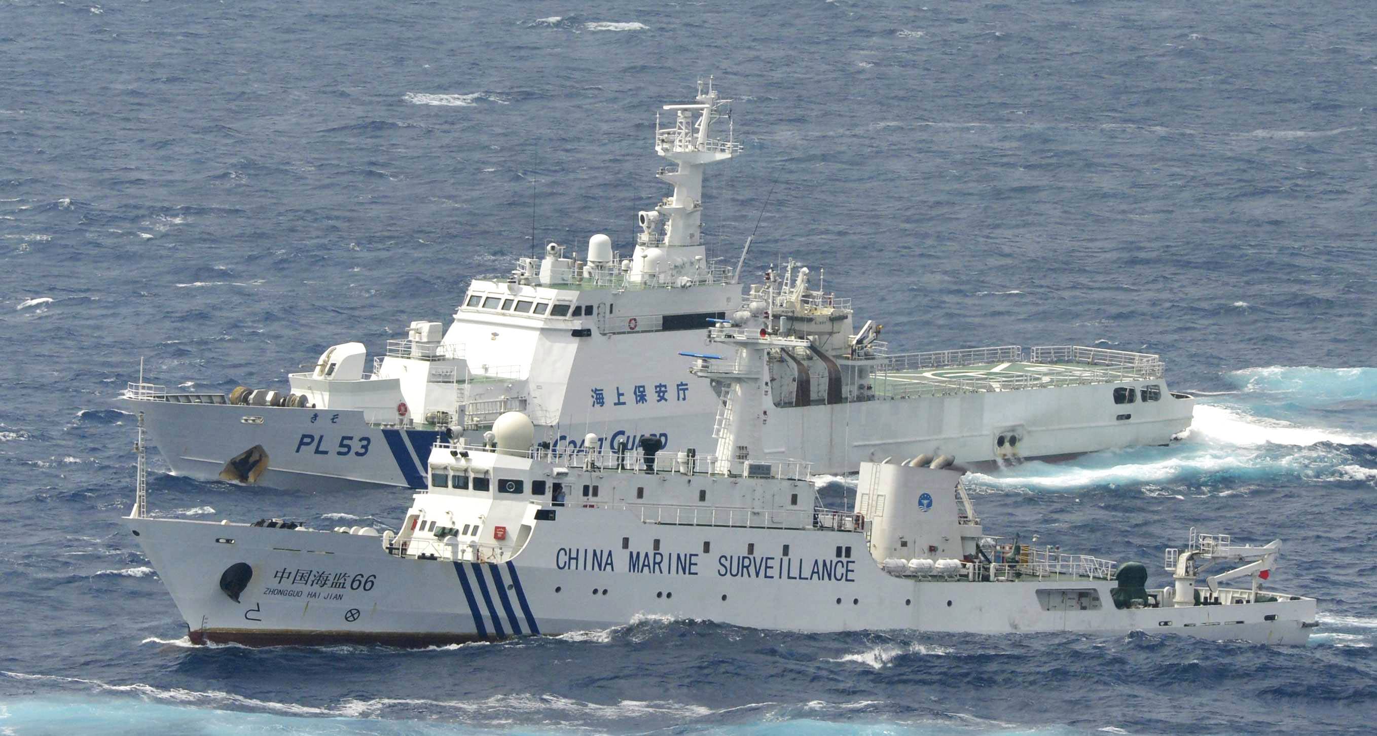 A Chinese marine surveillance vessel sails next to a Japan Coast Guard patrol ship in the East China Sea in September 2012. | KYODO