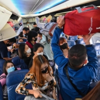 Passengers load luggage on a Thai Lion Air airplane before takes off at Don Muang Airport in Bangkok on Feb. 21. | AFP-JIJI