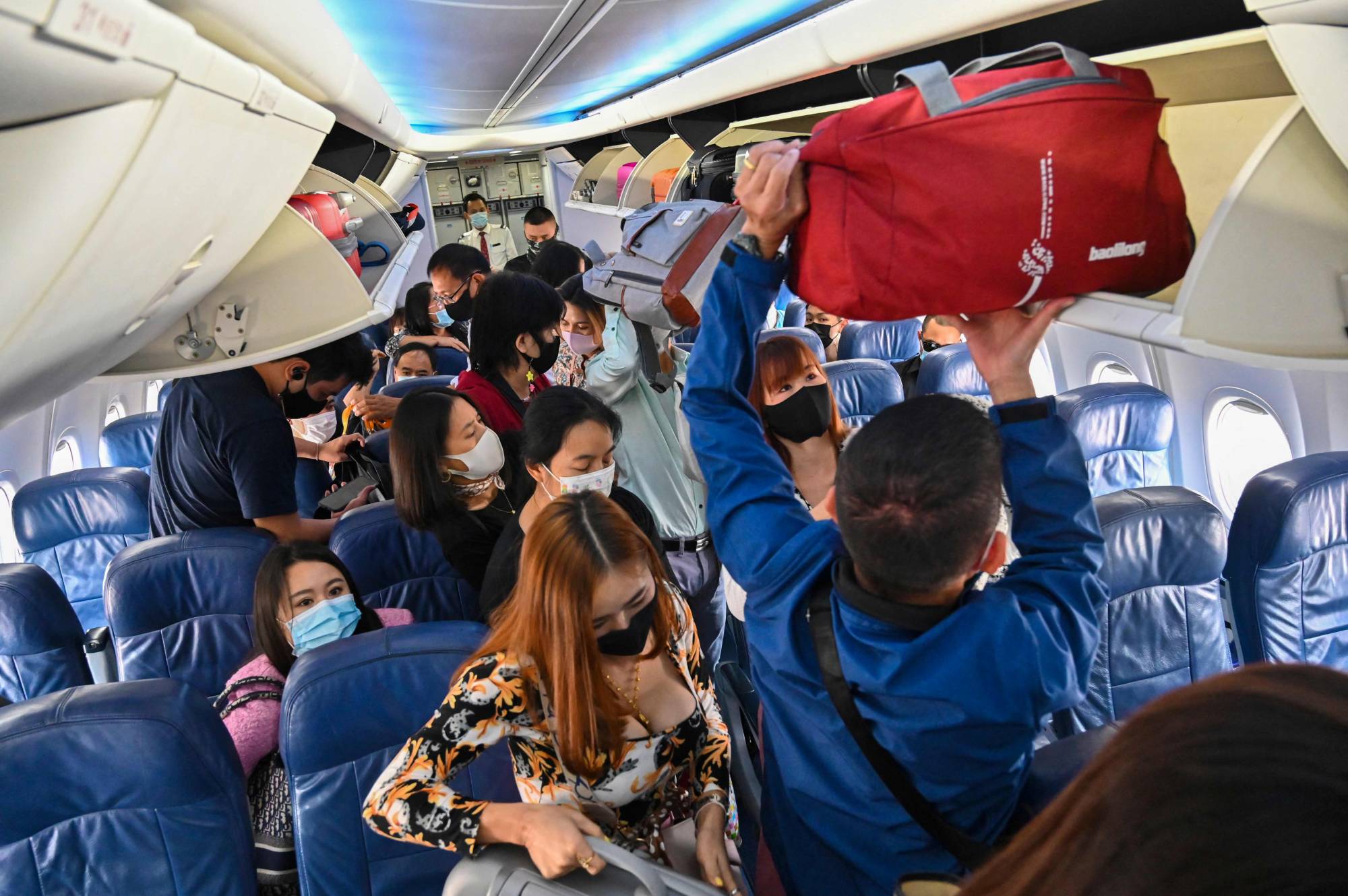 Passengers load luggage on a Thai Lion Air airplane before takes off at Don Muang Airport in Bangkok on Feb. 21. | AFP-JIJI