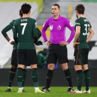 Referee David Cootes (second from right) waits for a video review during a Premier League match between Fulham and Tottenham in London on Thursday. | POOL / VIA AFP-JIJI