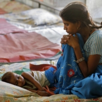A mother watches over her malnourished child in the Nutritional Rehabilitation Centre of Sheopur district in the central Indian state of Madhya Pradesh in April 2010. | REUTERS 
