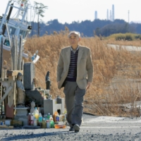Tetsuro Tsutsui, a member of the Citizens\' Commission on Nuclear Energy, walks in Namie, Fukushima Prefecture, to watch the tsunami-hit area in February in 2014. | KYODO
