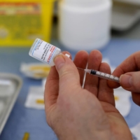 A health worker prepares a syringe with a dose of the Moderna COVID-19 vaccine at a vaccination center in Calais in France on Thursday.  | REUTERS
