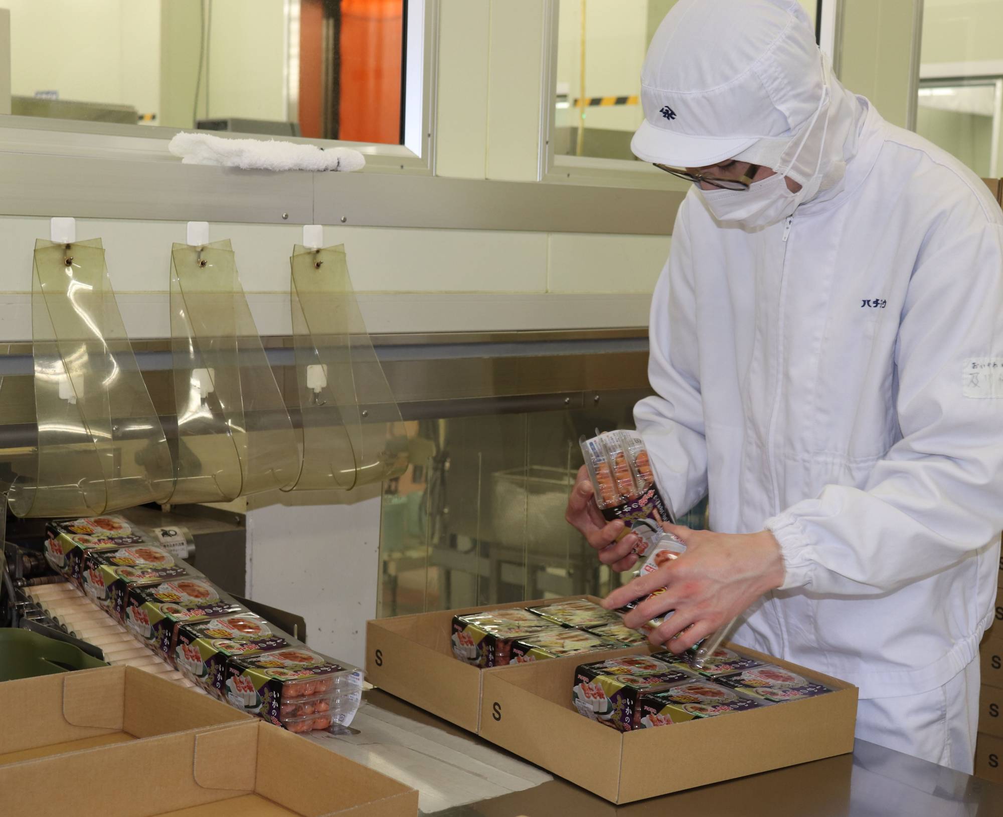 A worker at seafood processing company Hachiyo Suisan Co. in Kesennuma, Miyagi Prefecture, packages products for shipment in February. | Kahoku Shimpo 