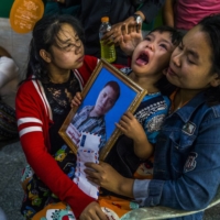 Shwe Yote Hlwar, 5, holds a portrait of her father, Zwe Htet Soe, 26, who was shot and killed while protesting on Wednesday, during his funeral in Yangon, Myanmar, on Friday.  | THE NEW YORK TIMES