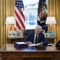 U.S. President Joe Biden signs the American Rescue Plan, a package of economic relief measures to respond to the impact of the COVID-19 pandemic, inside the Oval Office at the White House in Washington on Thursday. | REUTERS