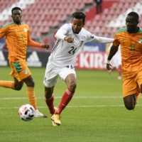 Musashi Suzuki (left) controls the ball while Cote d\'Ivoire\'s Eric Bailly defends during a friendly in Utrecht, Netherlands on Oct. 13, 2020. | REUTERS