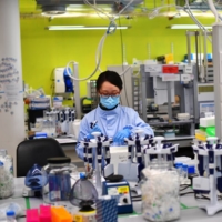Scientists work at a laboratory where they sequence novel coronavirus genomes at COVID-19 Genomics UK, on the Wellcome Sanger Institute\'s campus south of Cambridge, England. | REUTERS 