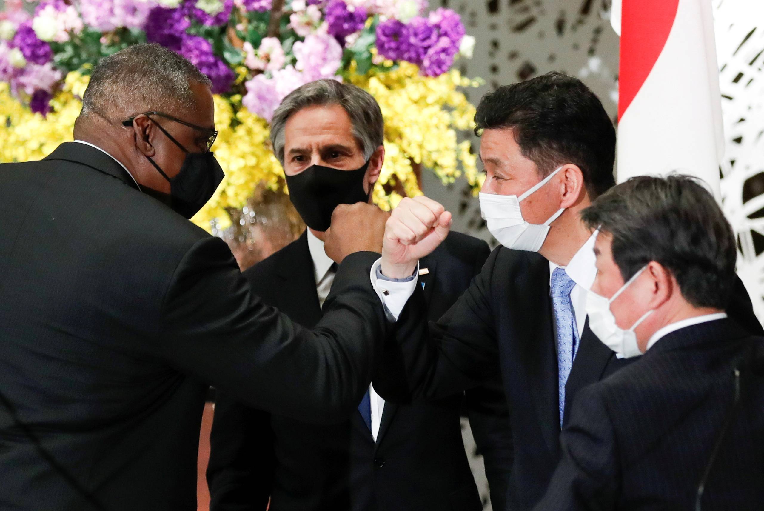 U.S. Defense Secretary Lloyd Austin (left) elbow bumps Japanese Defence Minister Nobuo Kishi as Foreign Minister Toshimitsu Motegi and U.S. Secretary of State Antony Blinken watch after a joint news conference following their 'two-plus-two' meeting at the Iikura Guesthouse in Tokyo on Tuesday. | POOL / VIA REUTERS