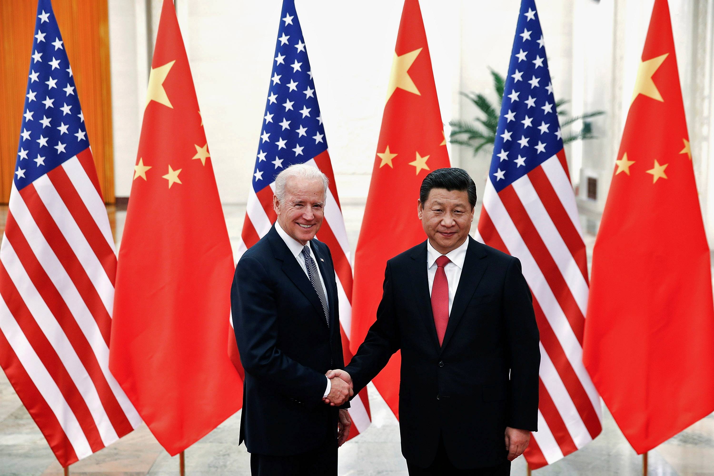 Chinese President Xi Jinping shakes hands with then-U.S. Vice President Joe Biden inside the Great Hall of the People in Beijing in December 2013. | POOL / VIA REUTERS