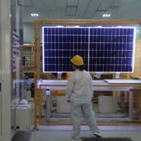 A worker conducts a quality-check of a solar module product at a factory in Xian, China. | REUTERS