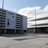 A poster promotes an exhibition of works by artist Banksy at the Messe Basel fairground at Messeplatz square in Basel, Switzerland, on March 18. | REUTERS 